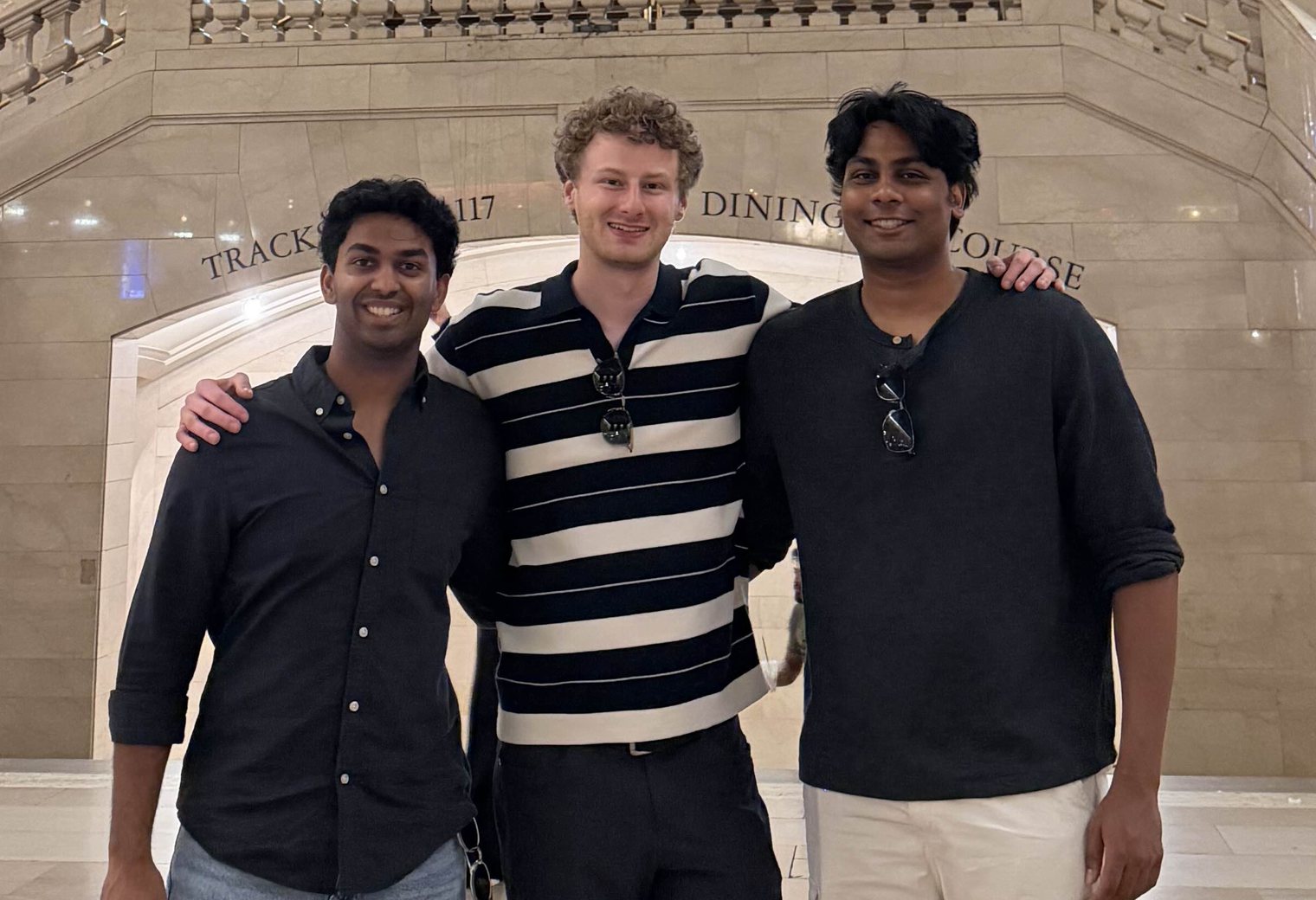 The three founders of Janus Labs standing together in Grand Central Terminal, smiling. From left to right: Atharva, Ben and Akshat.